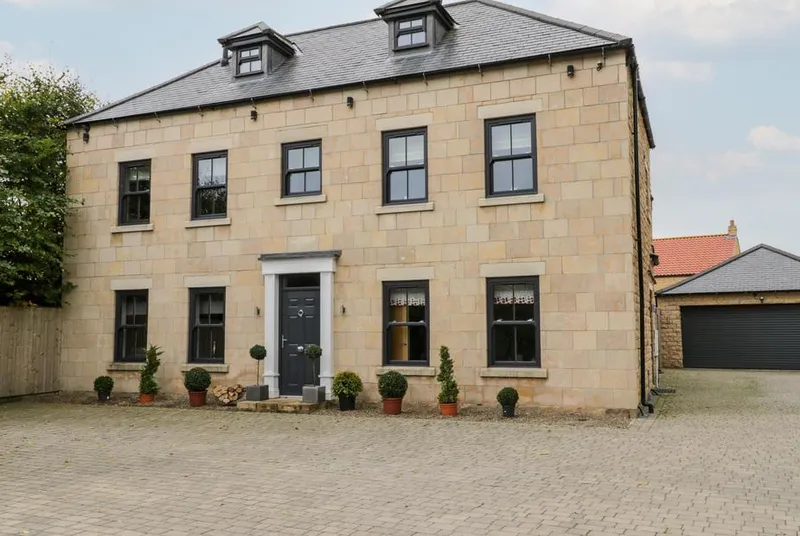 Seamer Manor House stone facade with topiary and block paving driveway