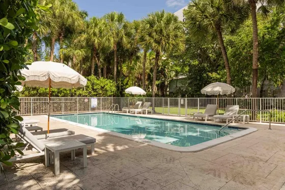 Swimming pool with two chairs and umbrellas