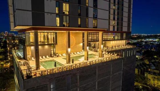 Night pool deck with lounge chairs and a glowing orange circle