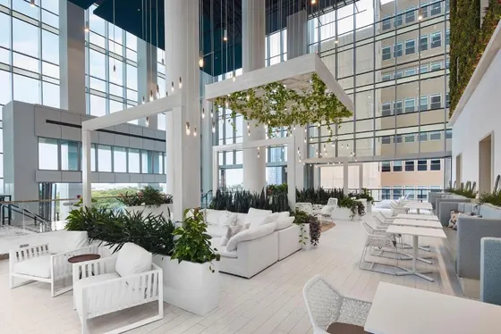 Lobby with white chairs and tables and windows