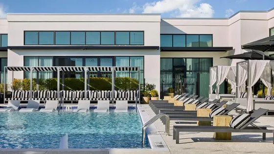 Pool with chairs and umbrellas in front of a building