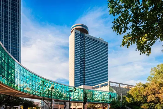 Tall building with a glass walkway in front of it