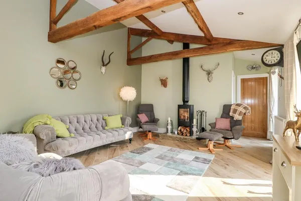 Snave Cottage living room with Chesterfield sofas, wood burner and oak beams