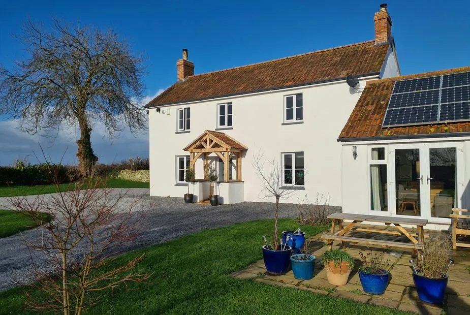 Somerset House white farmhouse exterior with garden and blue sky