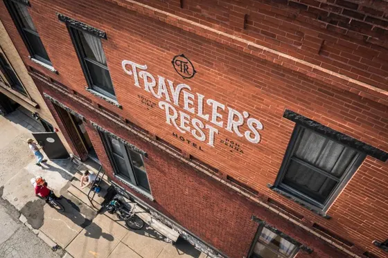 Red brick hotel exterior with painted lettering and bicycles beside the entrance