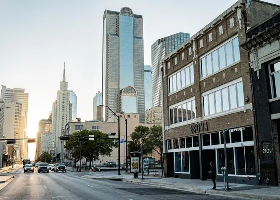 Brick SOVA corner building with downtown towers behind it