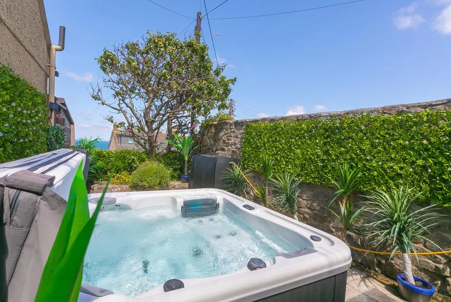 Spernenwyn garden hot tub with glimpsed sea beyond