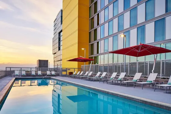Pool with chairs and umbrellas next to a building