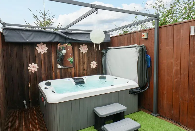 Stag Lodge Holiday Retreat hot tub with flower wall decorations and canopy