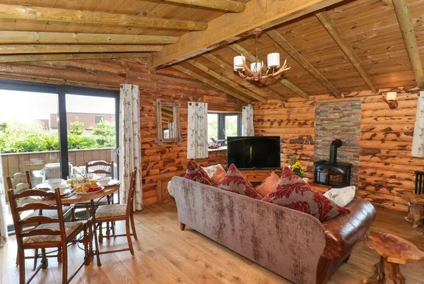 Stag Lodge Holiday Retreat open-plan living room with antler chandelier and wood burner