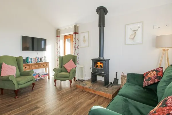 Stoney-Brook Lodge living room with green sofa and wood burner