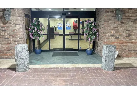 Lobby with three potted plants in front of a building