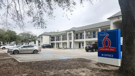 Blue Studio 6 sign in front of a white two-story motel