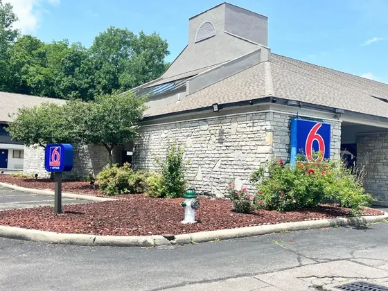 Stone motel with a blue Motel 6 sign and rose bushes