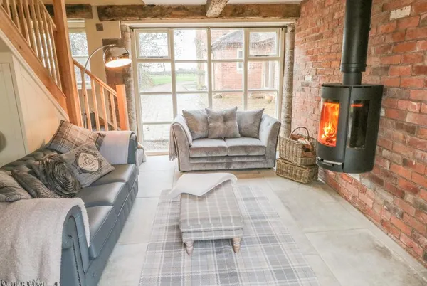 Orchard Barn living room with lit wood burner and exposed beams