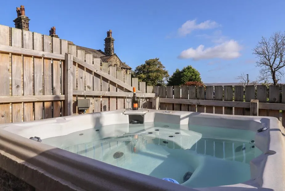 The Old Hen Shed hot tub with water and jets under blue sky