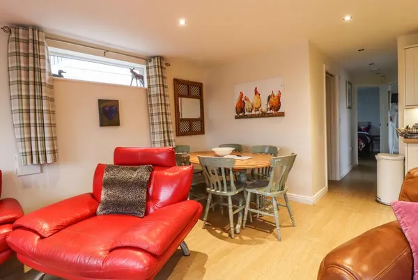 The Old Hen Shed living area with hen artwork and red sofas