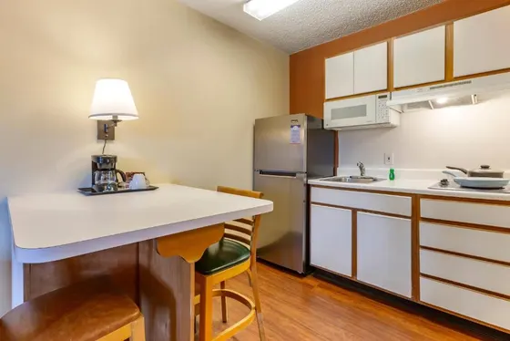 Small kitchenette with a stainless fridge and dining table