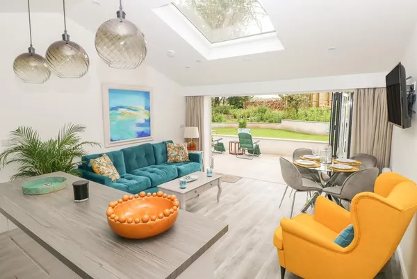 Summerhouse open-plan living room with skylight and bifold doors to garden