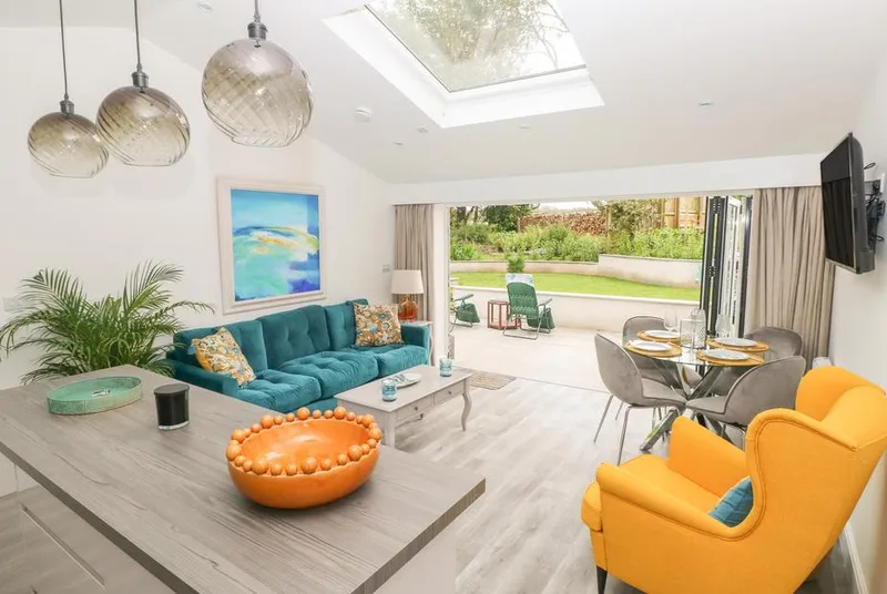 Summerhouse open-plan living room with skylight and bifold doors to garden
