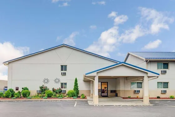 Beige hotel with a blue roof and covered entrance
