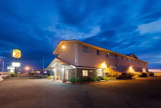 Three-story motel with warm lights and a Super 8 sign at twilight