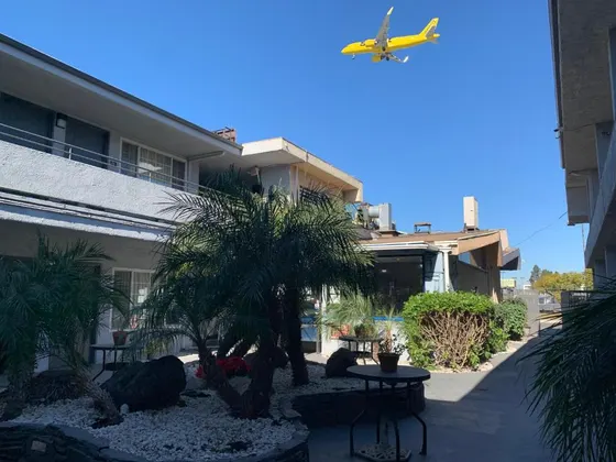Small yellow plane flying over a building