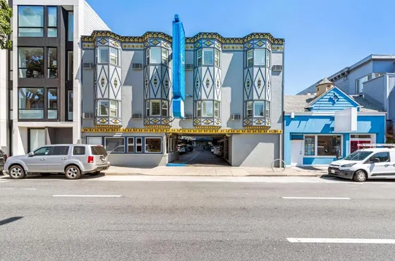 Large building with cars parked in front of it
