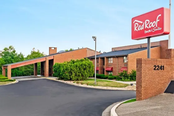 Brick hotel with a Red Roof Inn pole sign