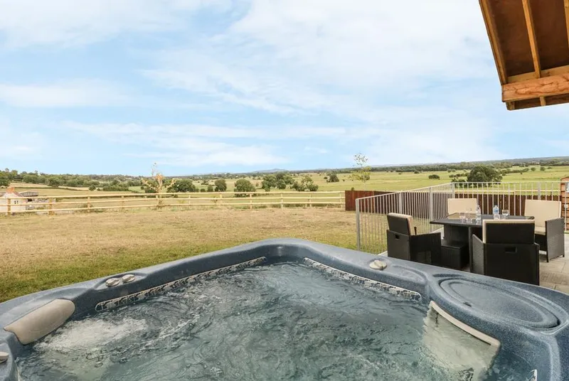 Swan Lodge Castle Farm hot tub with bubbling water overlooking Somerset Levels