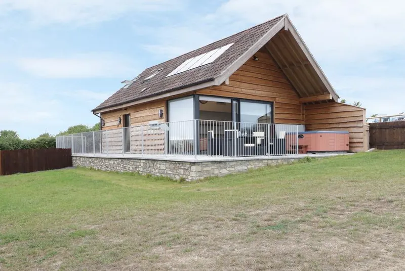 Swan Lodge Castle Farm timber-clad lodge from front lawn with skylights and balcony