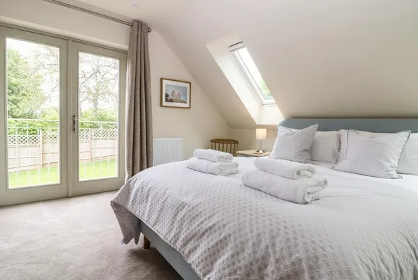 Tawny Cottage top-floor bedroom with doors and soft neutral decor