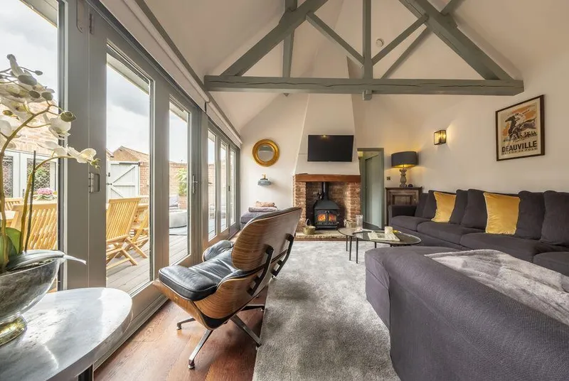 Tern Cottage vaulted living room with painted beams and glass bifold doors to deck