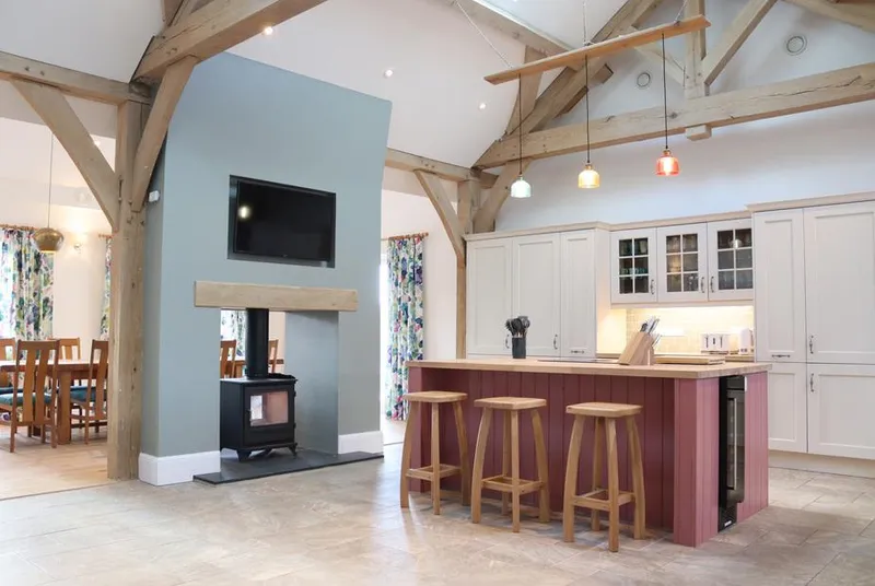 The Anchorage vaulted oak-beam open-plan living area with wood burner and kitchen island