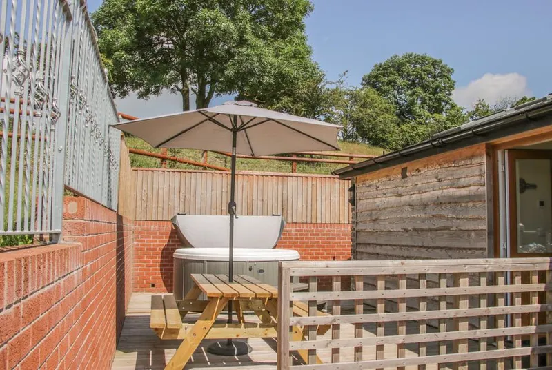 The Boundary Annex hot tub on the patio under an umbrella