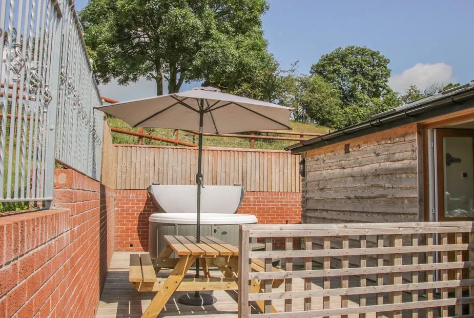 The Boundary Annex hot tub on the patio under an umbrella