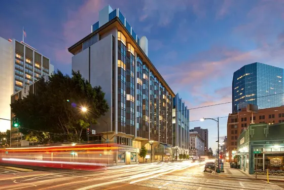 City street with a tall building and traffic