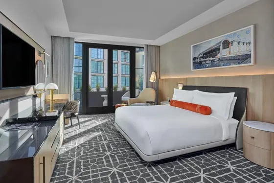 White-linen room with an orange bolster and balcony doors
