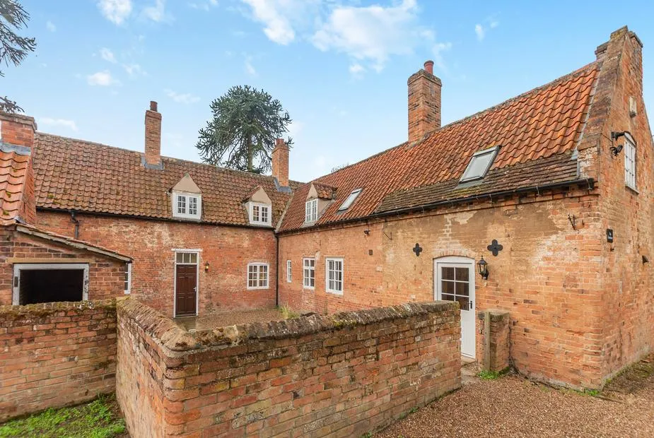 The Farmhouse brick courtyard exterior with historic farmhouse character