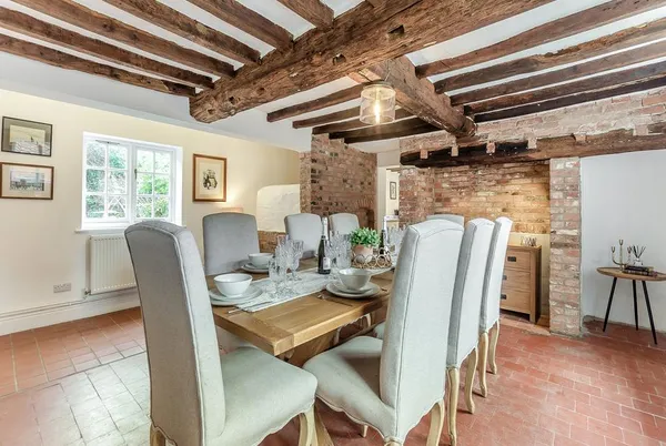 The Farmhouse beamed dining room with long rustic table