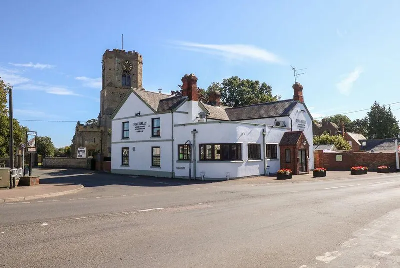 The Five Bells Inn converted pub exterior with church tower behind
