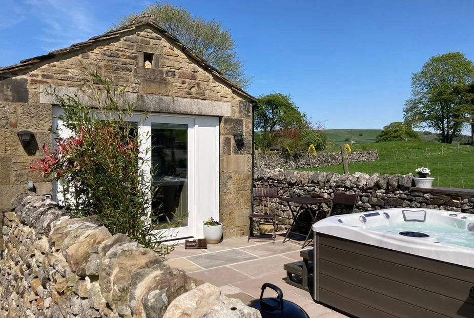 The Folly hot tub beside stone barn with Dales hillside