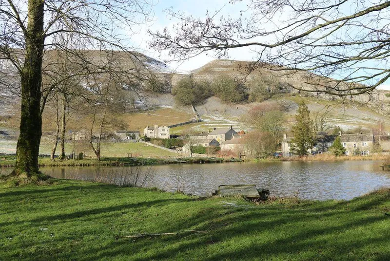 The Folly Yorkshire Dales village across water with hillside