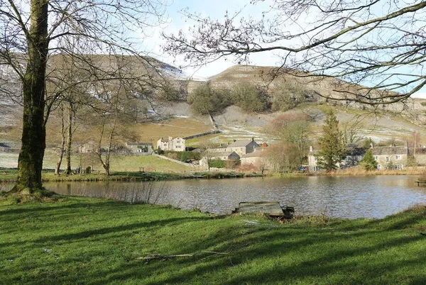 The Folly Yorkshire Dales village across water with hillside