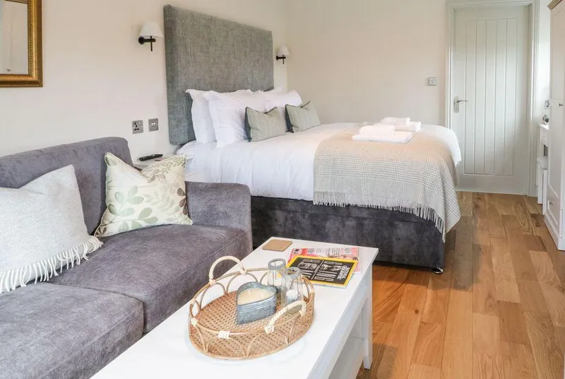The Folly cosy studio with grey sofa and oak floors