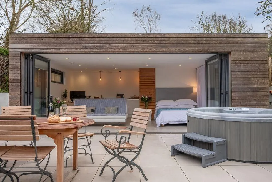 The Garden Room patio with hot tub and open bi-fold doors