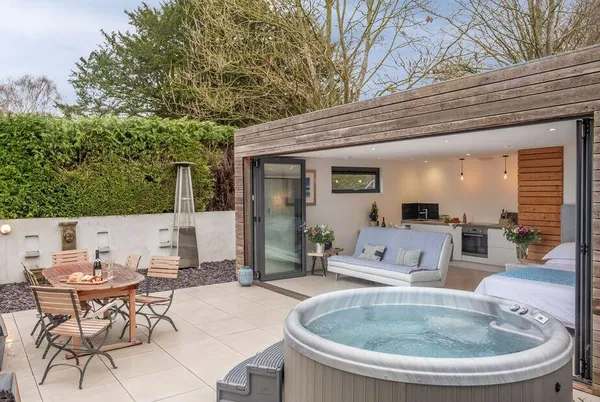 The Garden Room garden with hedge-lined patio and dining area