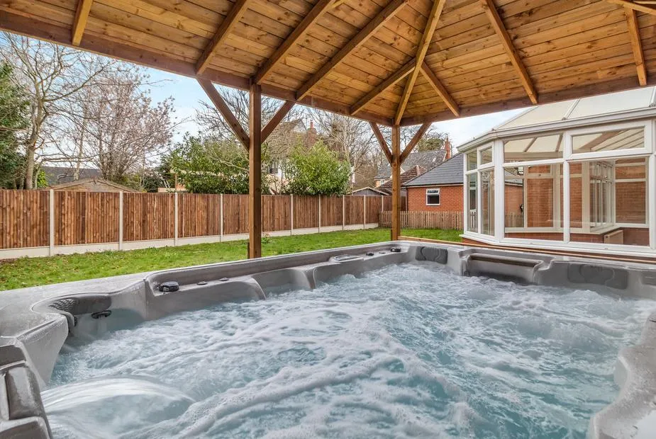 The Great Escape large covered hot tub beside the conservatory