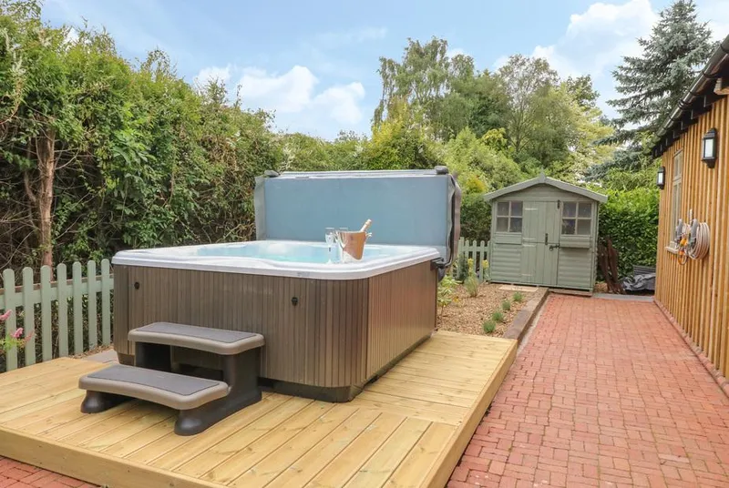 The Hen House hot tub on wooden deck with champagne bucket