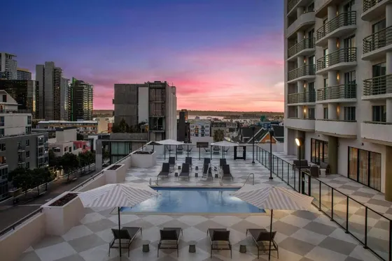 Rooftop pool with chairs and umbrellas on a building